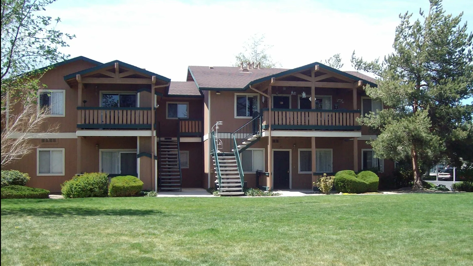 two story apartment building with grassy area in front at brooktree apartments