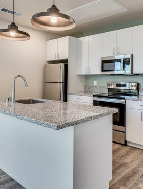 open kitchen with stainless steel appliances and floor to ceiling windows and patio door at oner midtown