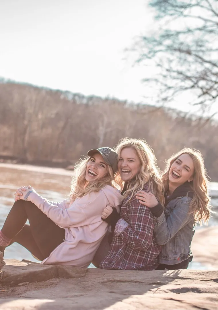 three women laughing near the river