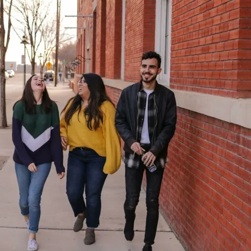 three people walking down the street laughing