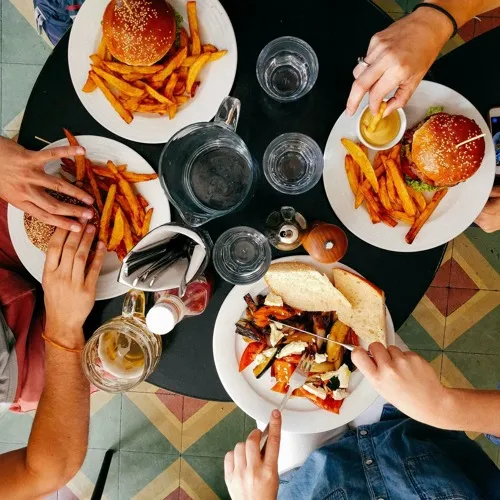 top view of a table of four people eating burgers
