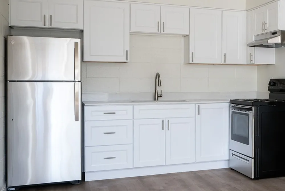 open kitchen with stainless steel appliances and wood like flooring at peace street apartments