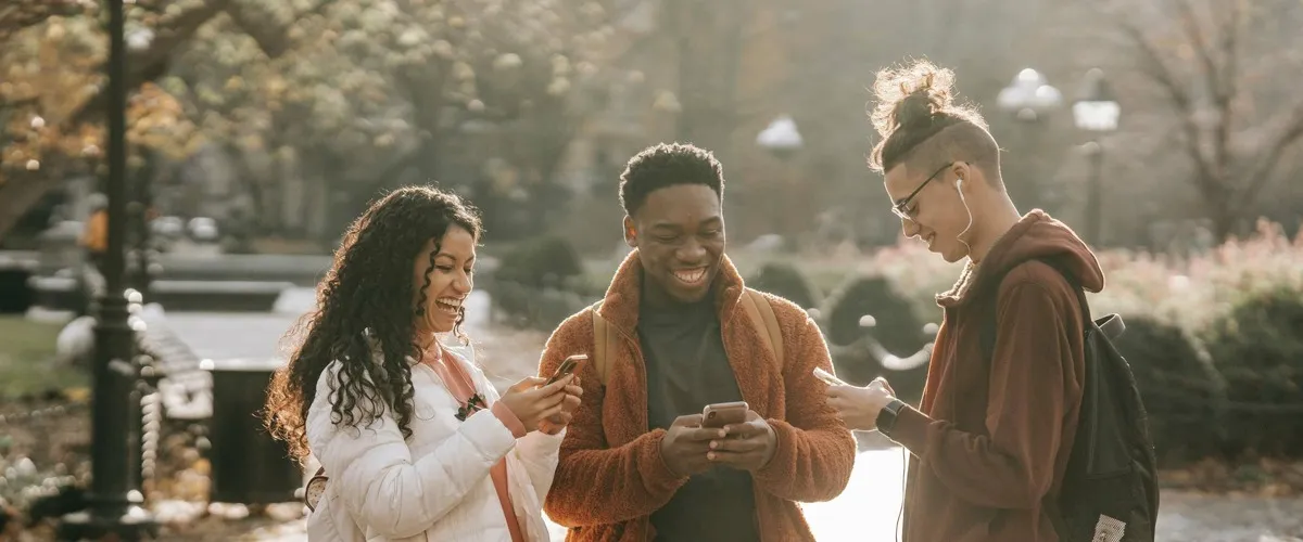 3 people interacting with their phones and having a good time