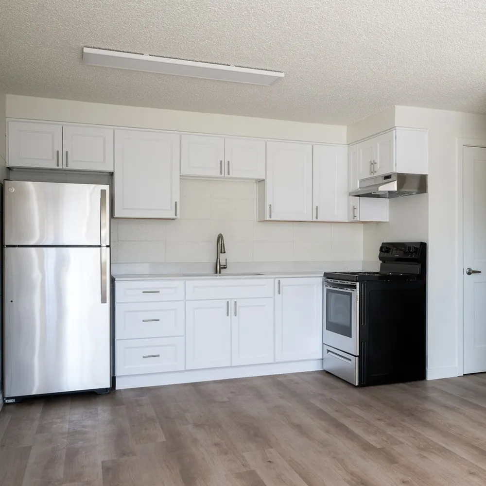 open kitchen with stainless steel appliances and wood like flooring at peace street apartments