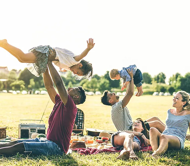 two families at the park playing with their kids
