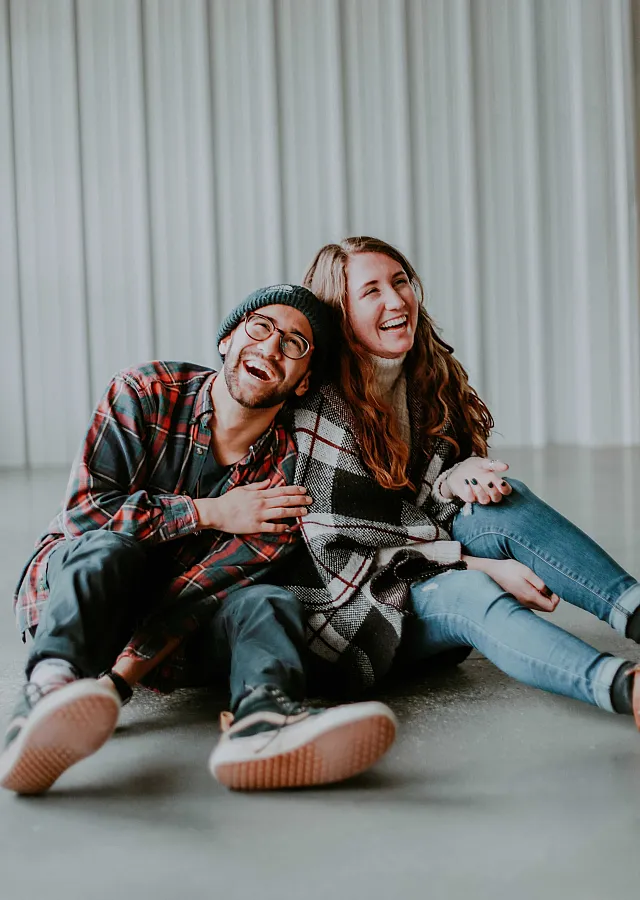 a couple laughing while sitting on the floor