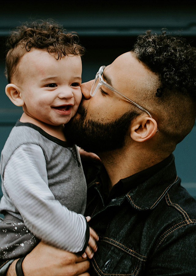 dad kissing son on the cheek