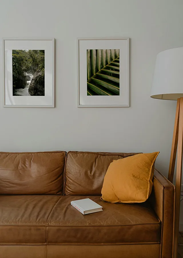 brown leather sofa with a yellow accent pilow
