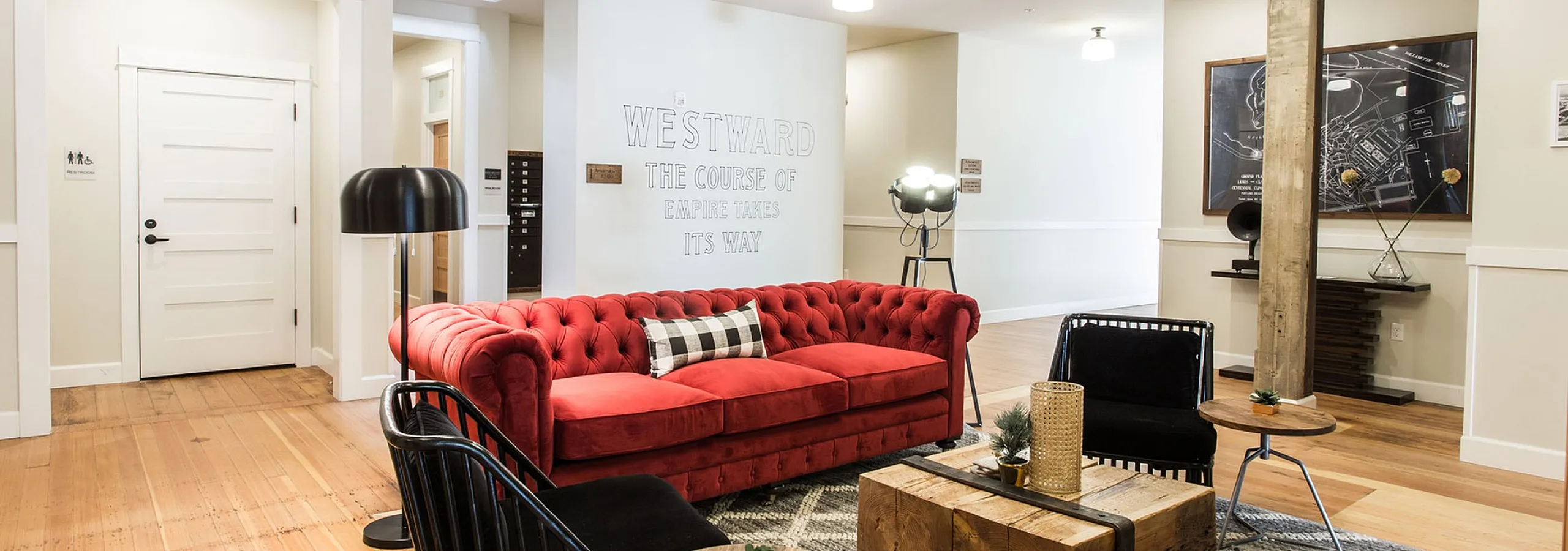 lounge area with red sofa and black chairs at fairmount apartments