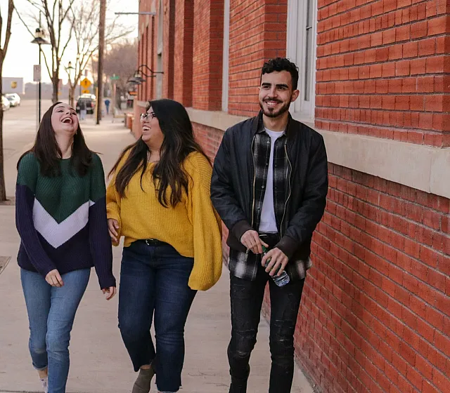 3 young people walking in the street laughing
