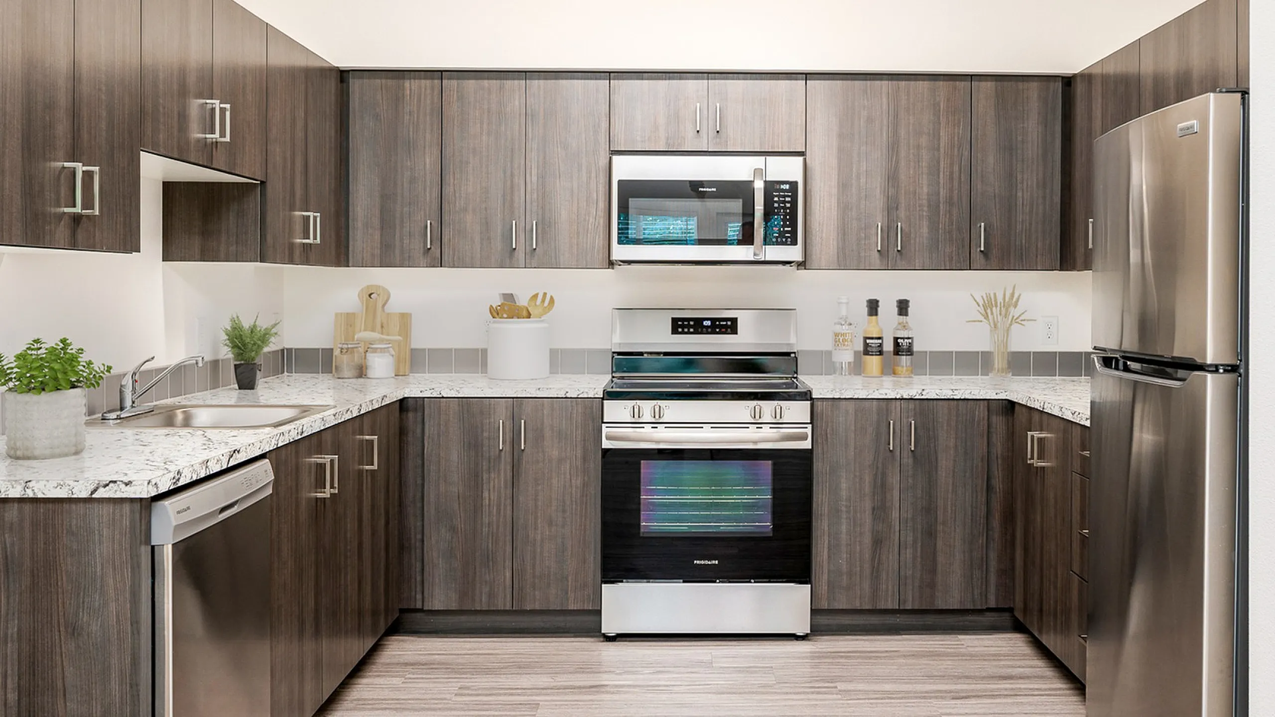 kitchen with dark cabinets and stainless steel appliances at Pacific Ridge Apartments
