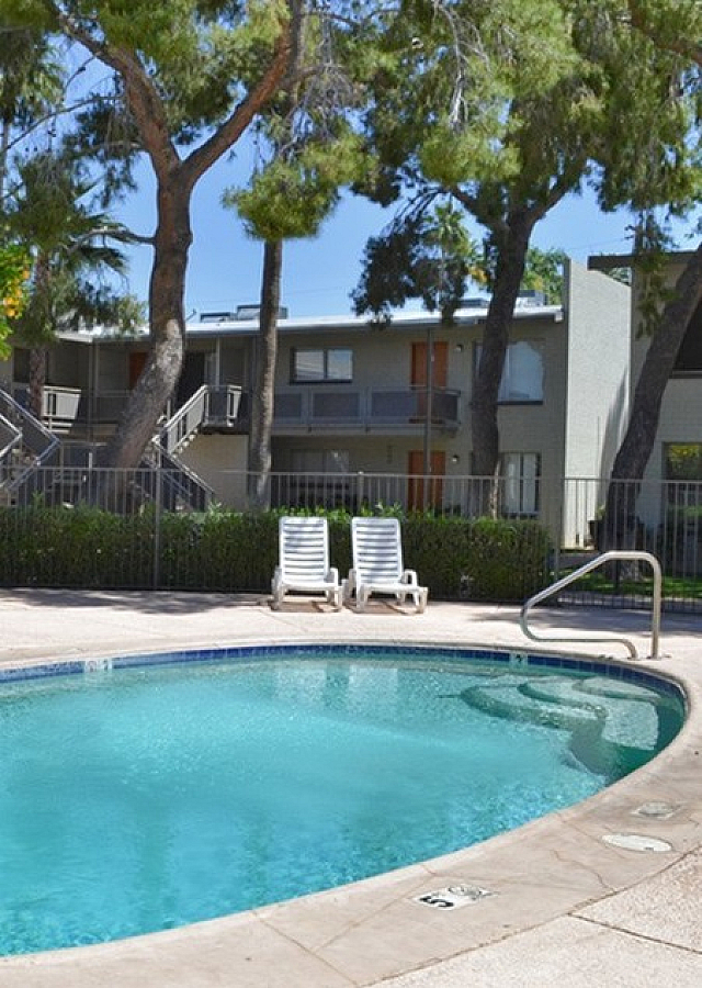 oval shaped pool with lounge chairs and tables at solaris on university