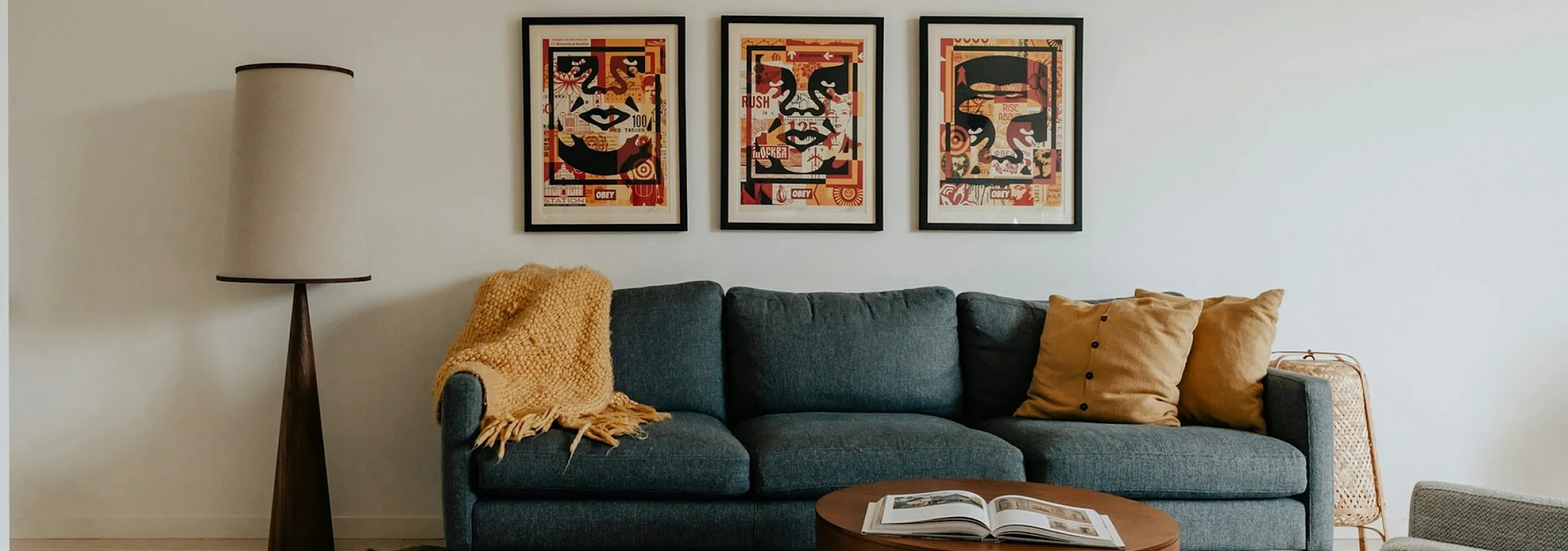 blue sofa with yellow accent pillows and yellow trow and round coffee table with open book