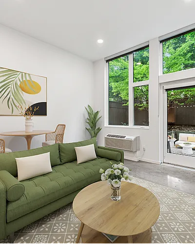 living room with green couch mirror and media console