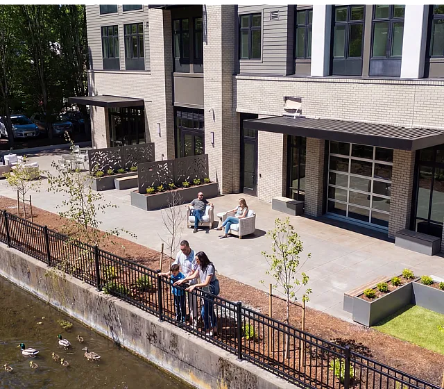 outdoor area with seating close to the water and a family of ducks