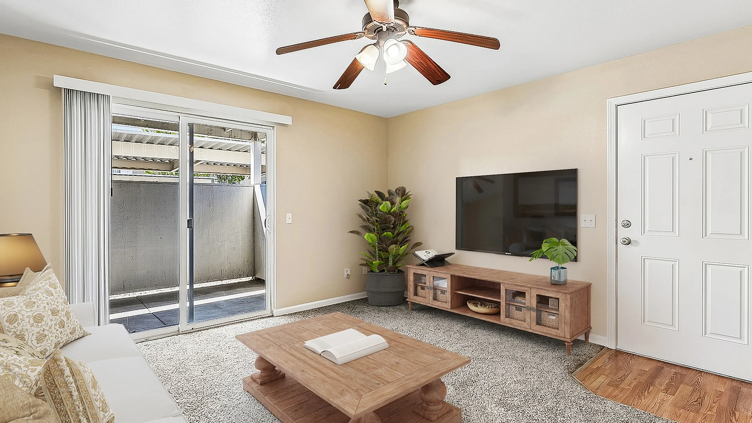 virtually staged living room with sofa, coffee table, and TV.