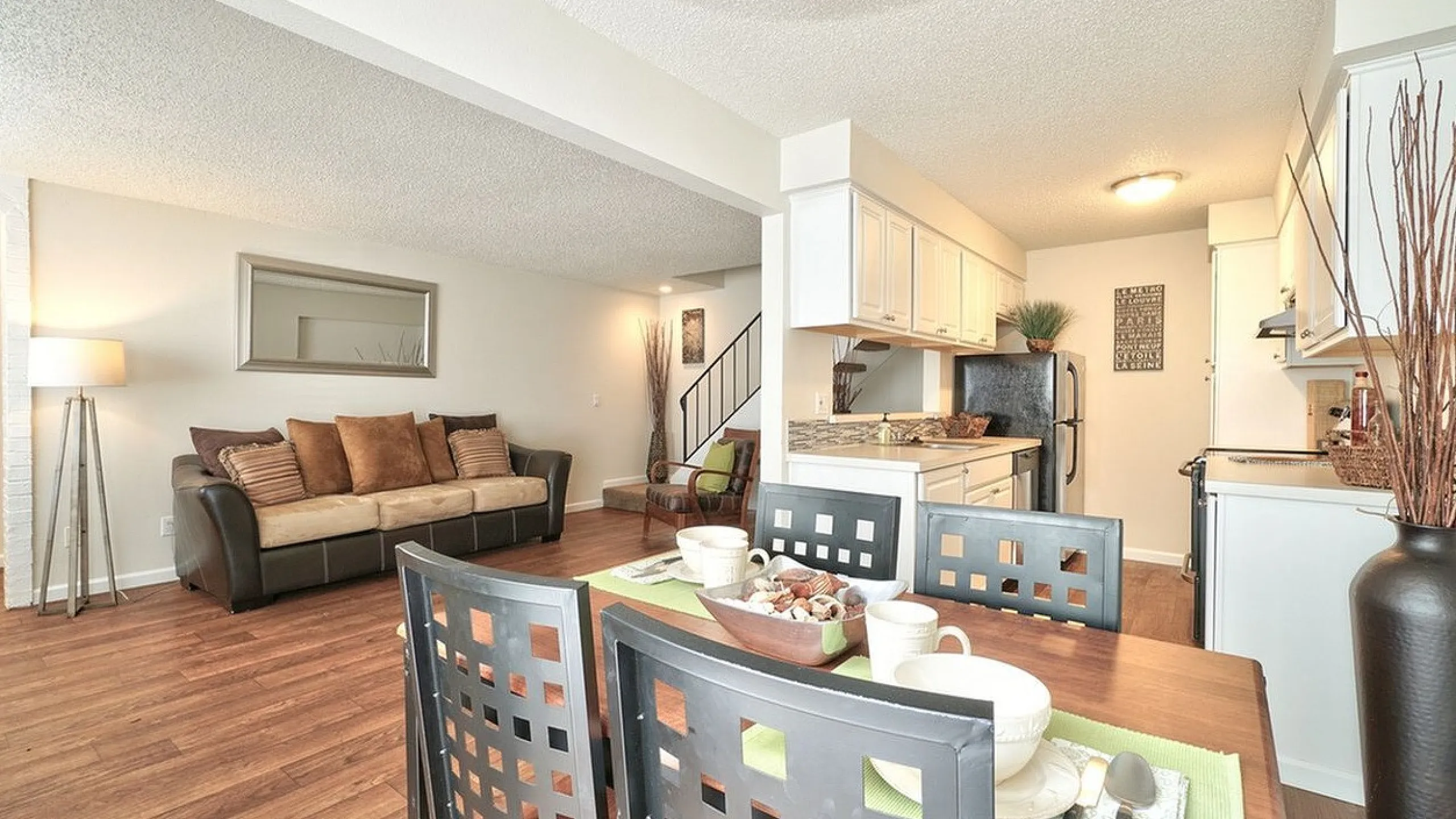 Cozy dining table arrangement next to a well-lit living area at CAMPBELL PARK.