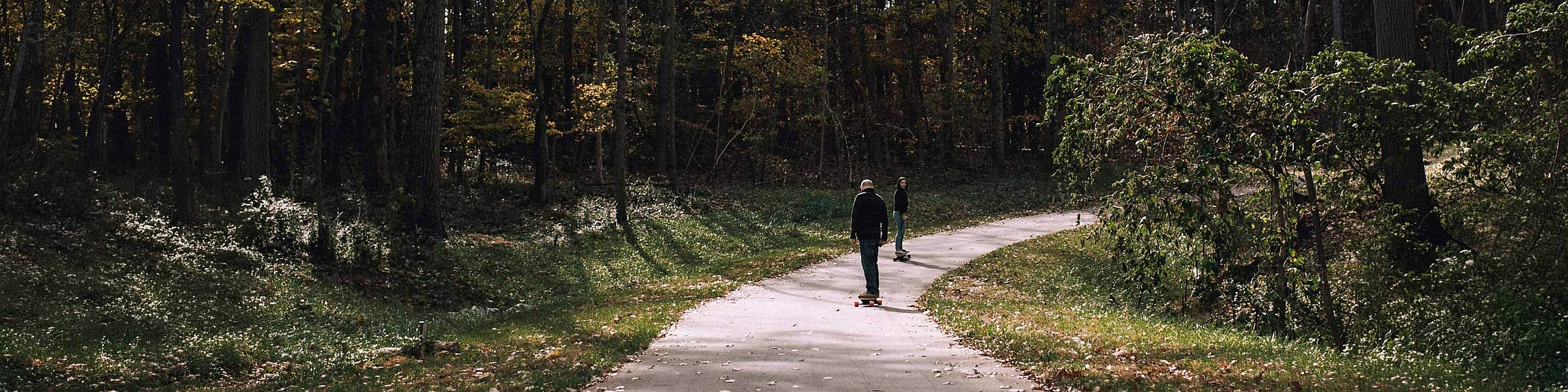 two people skating on the road