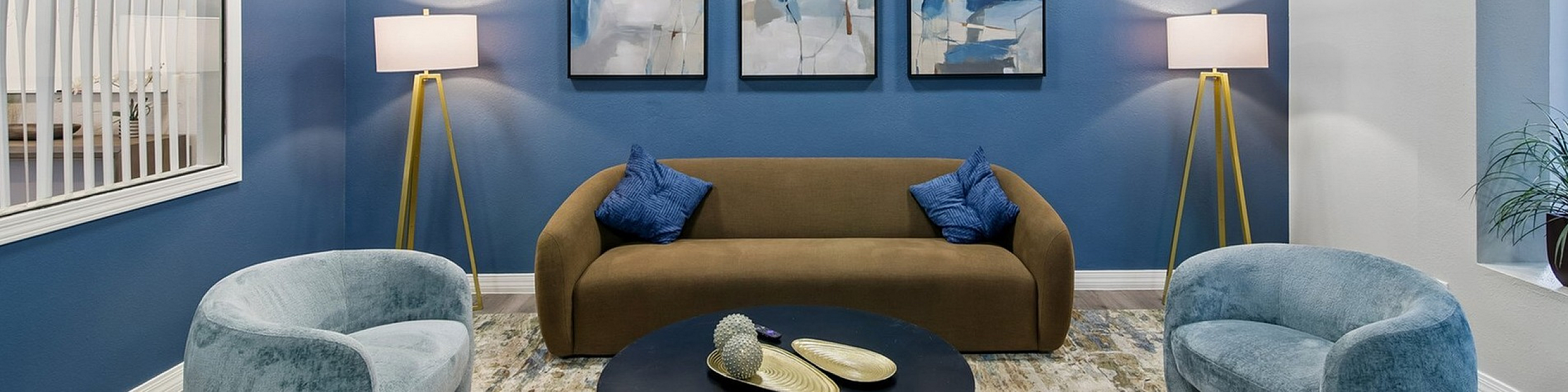 green sofa and blue chairs in the lobby of ventura villas