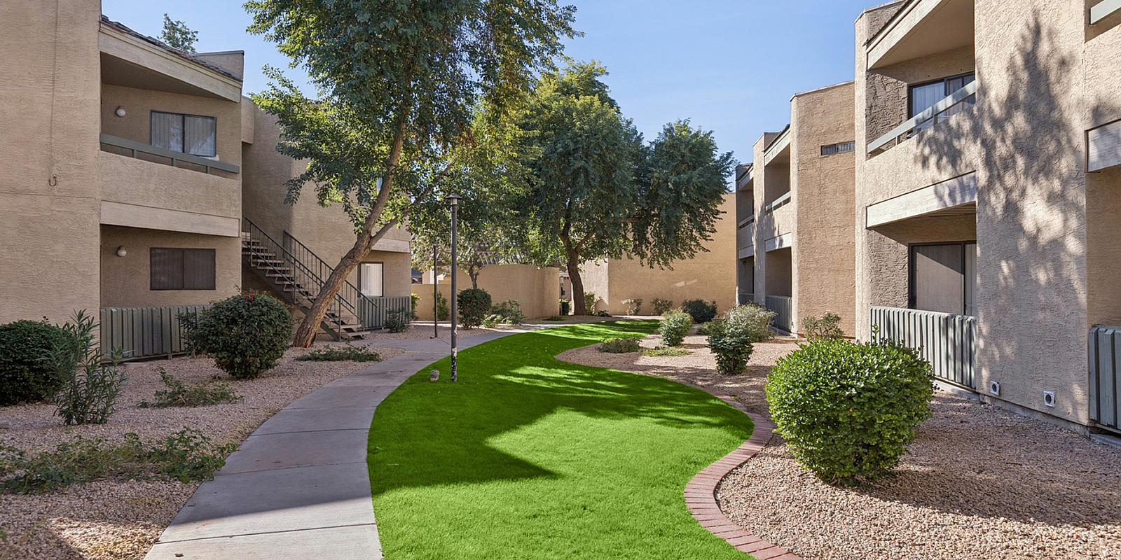 grassy courtyard and walkway to clubhouse and pool at Silver Creek Apartments