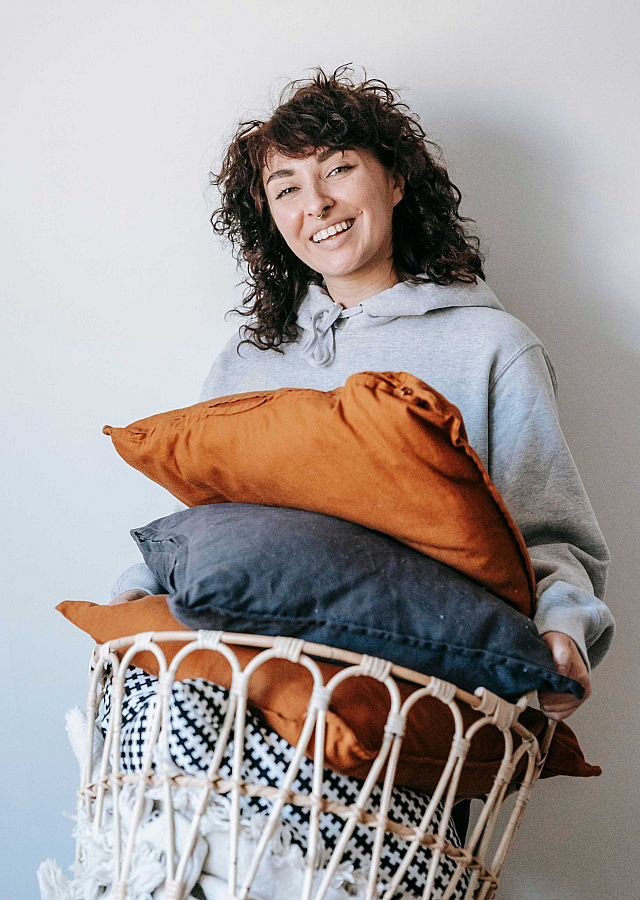 woman carrying a basket of pillows