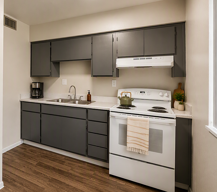Kitchen at Deer Valley Village with grey cabinets, white electric range, and laminate countertops.