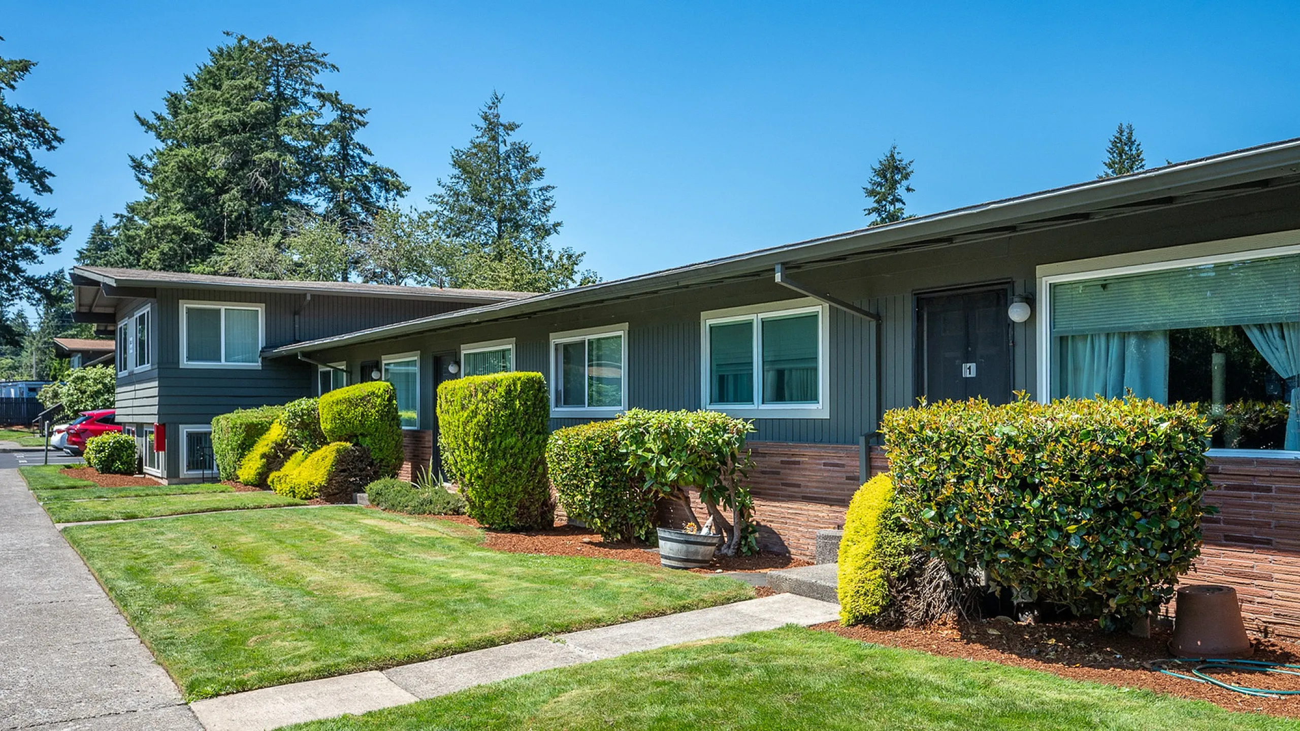 exterior of hidden court apartments with grass and exterior entries