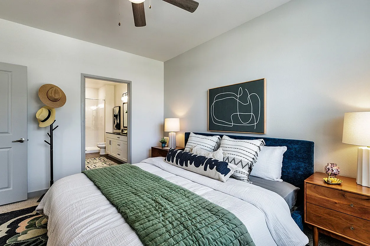Modern bedroom with stylish decor and an ensuite bathroom, featuring a plush bed and accent lighting.