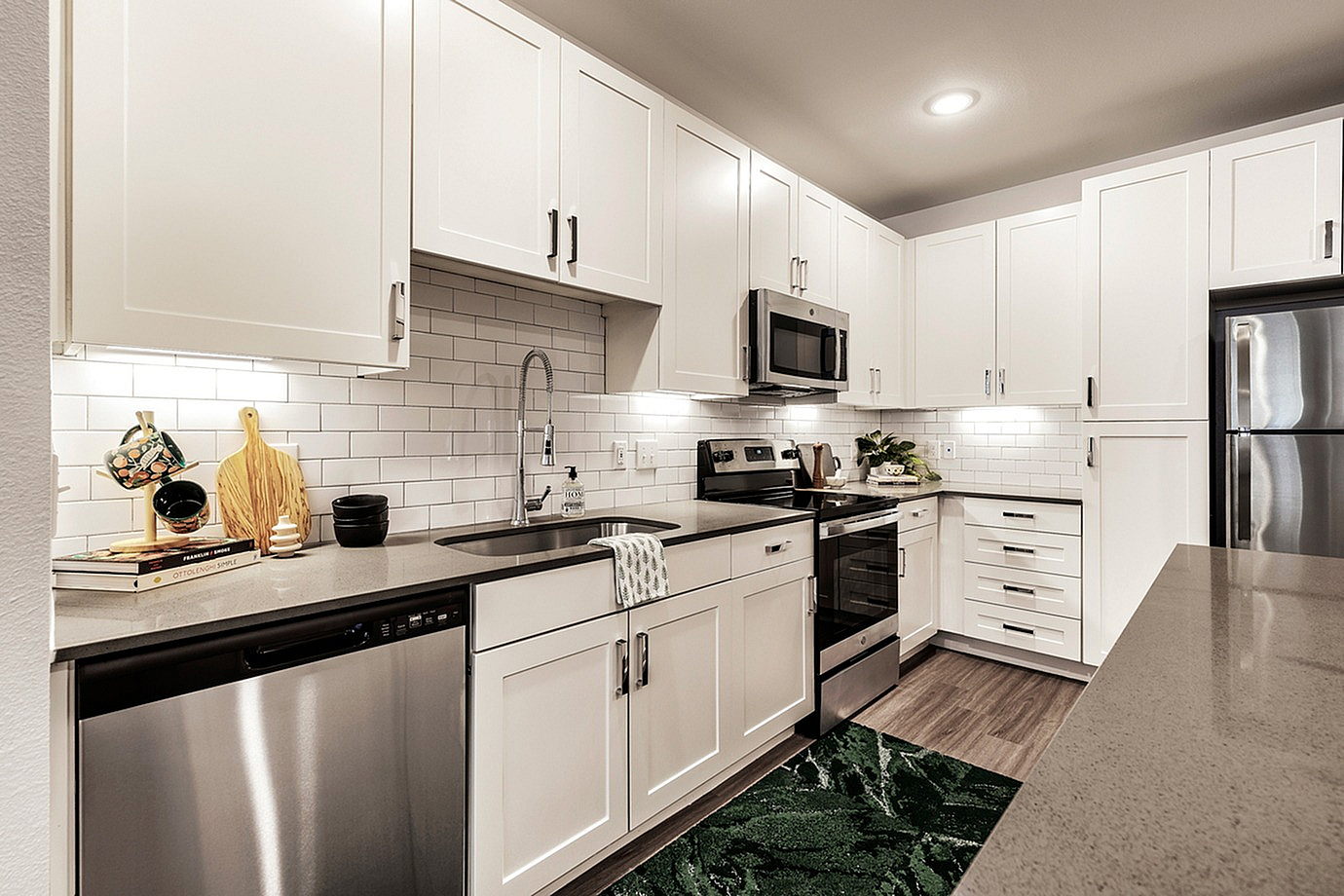 Modern kitchen interior with sleek white cabinets, stainless steel appliances, and a stylish backsplash.