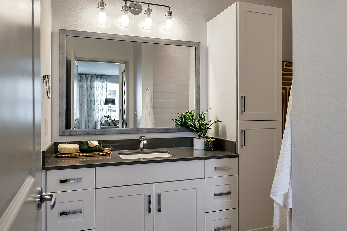 Modern bathroom with sleek vanity, large mirror, and elegant lighting.