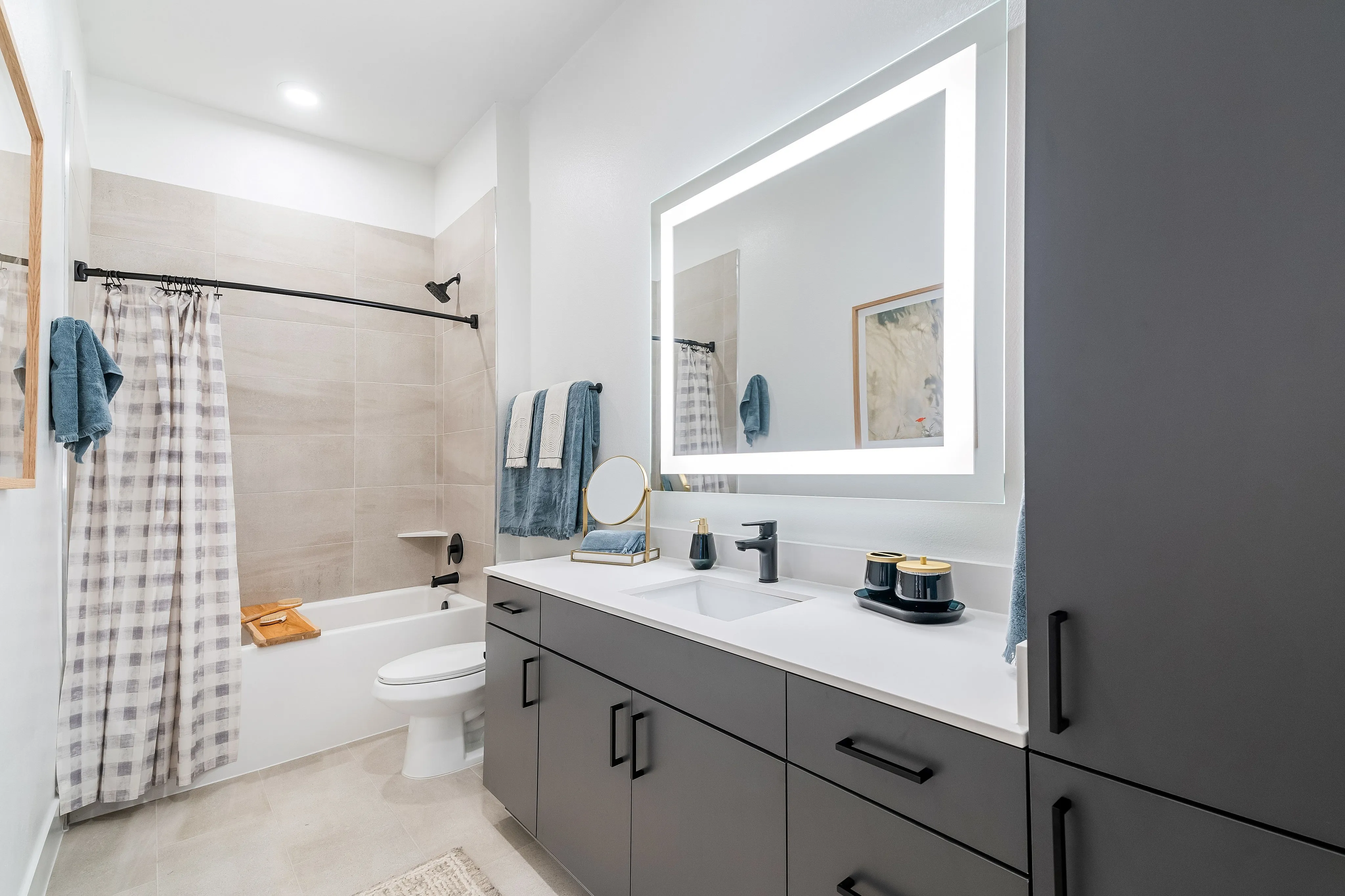 houston apartments | apartments near memorial city | apartments zoned to Katy ISD | apartments near hwy6 |Contemporary bathroom design featuring a sleek vanity with illuminated mirror, modern fixtures, and elegant neutral tones.