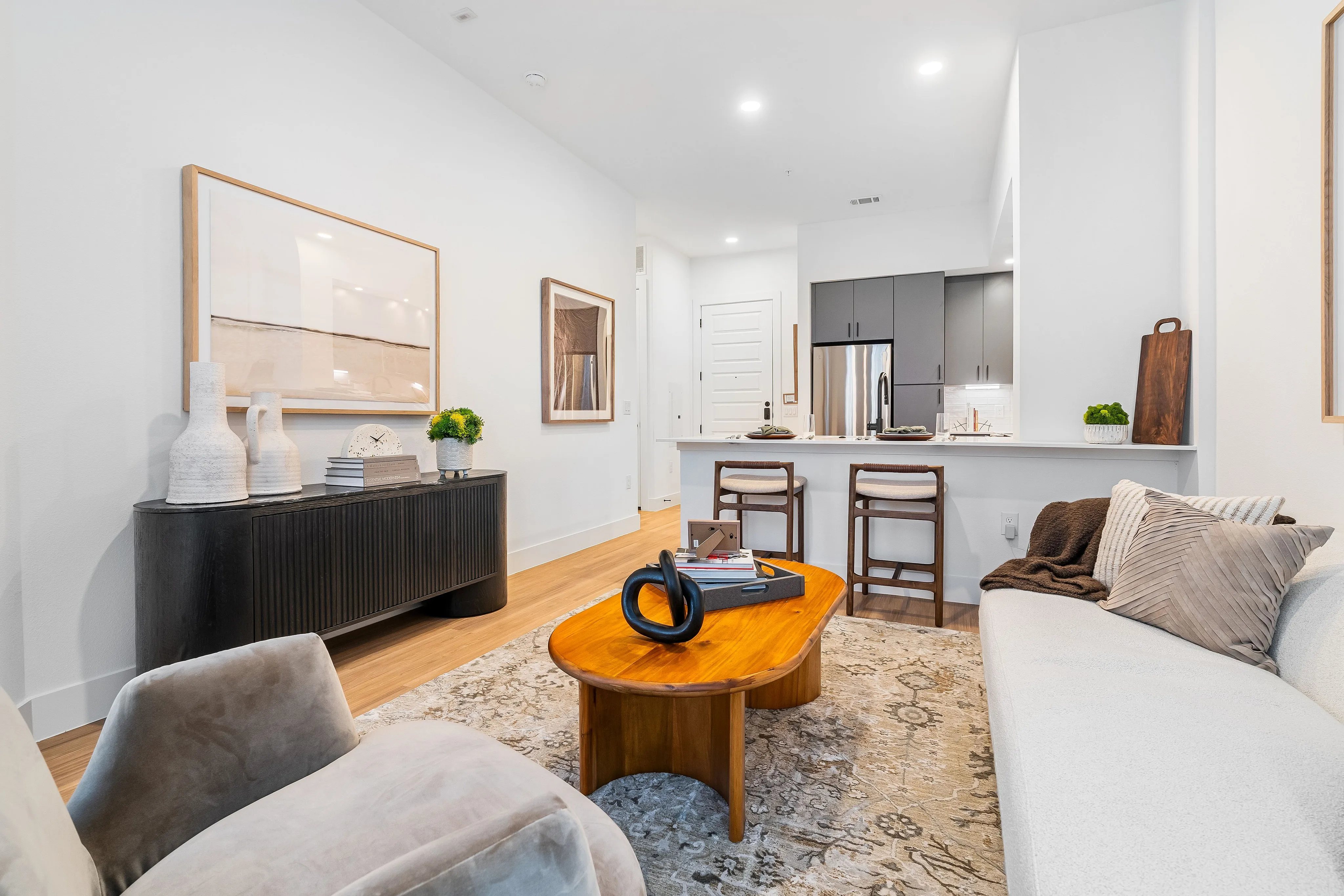 houston apartments | apartments near memorial city | apartments zoned to Katy ISD | apartments near hwy6 |Elegant open-concept living space with chic modern decor, featuring a cozy seating area, stylish wooden coffee table, and a sleek kitchen with bar seating.