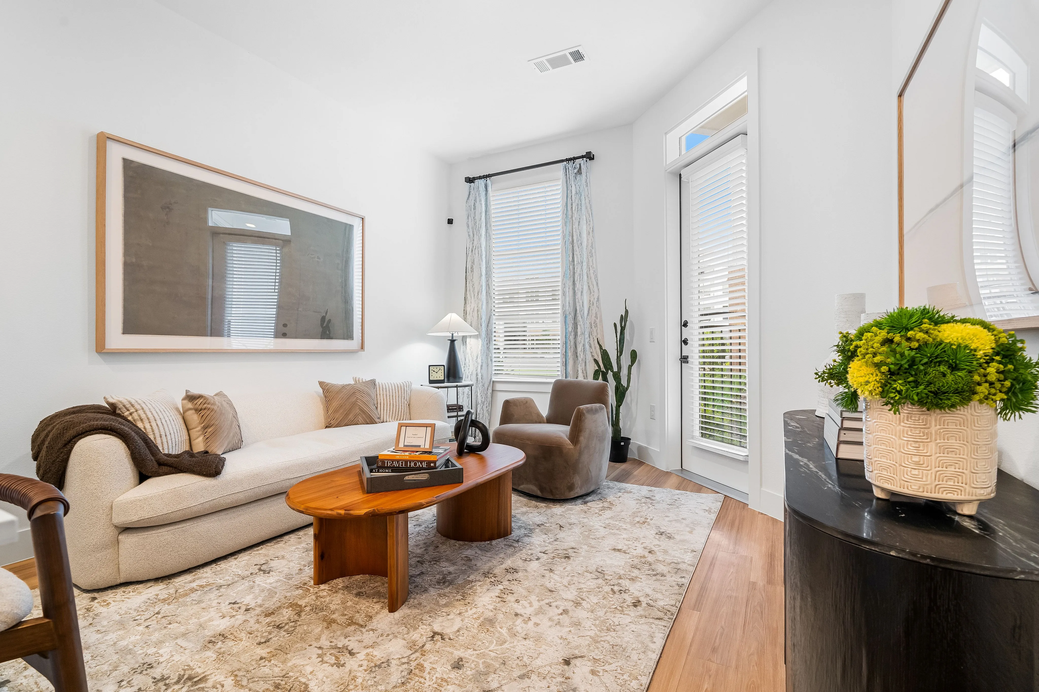 houston apartments | apartments near memorial city | apartments zoned to Katy ISD | apartments near hwy6 |Bright and inviting living room with a modern beige sofa, elegant decor, and lush greenery, perfect for relaxation.