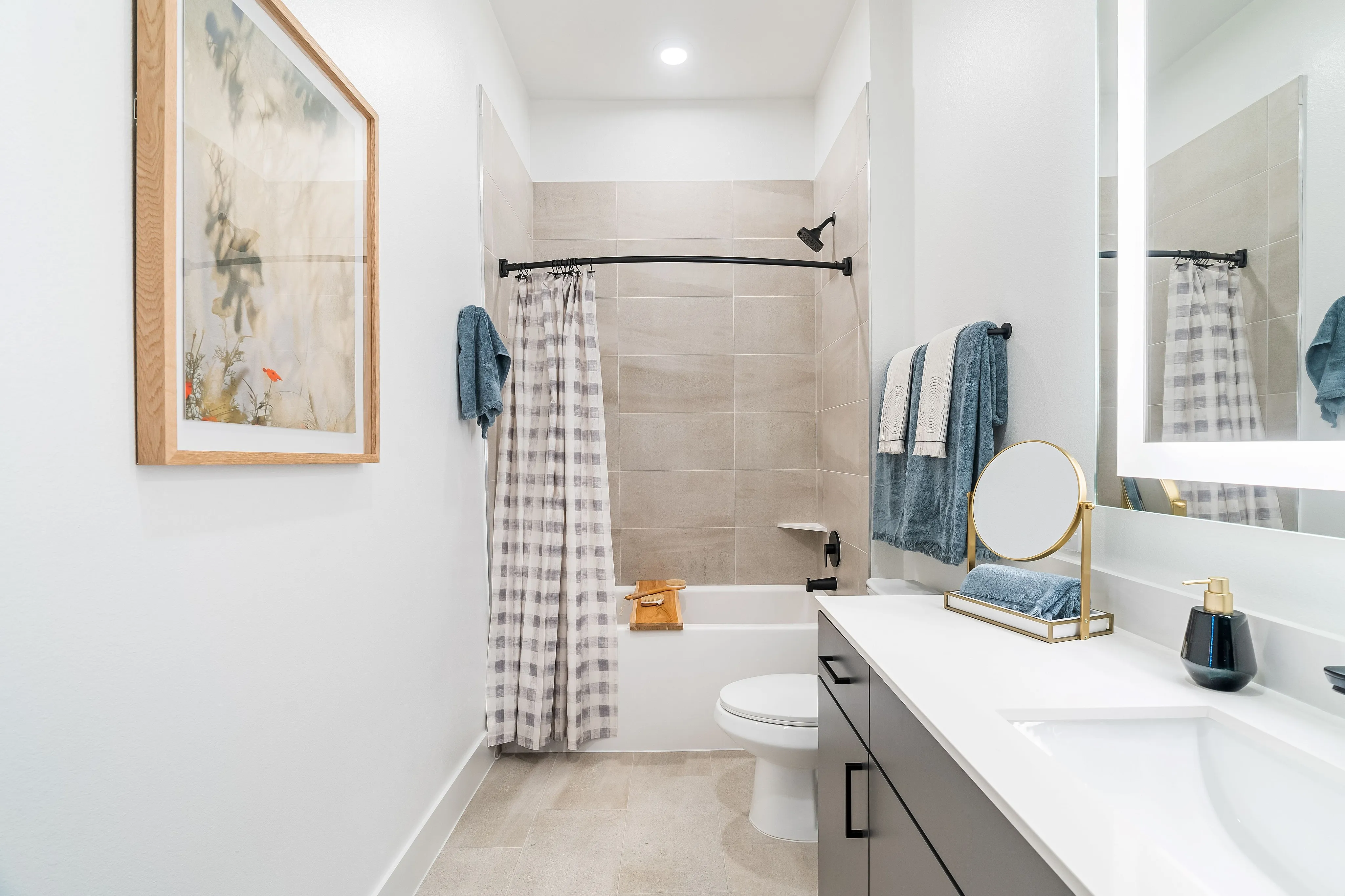 houston apartments | apartments near memorial city | apartments zoned to Katy ISD | apartments near hwy6 |Bright and modern bathroom featuring a sleek vanity with a large mirror, elegant shower area with tile walls, and tasteful decor elements.
