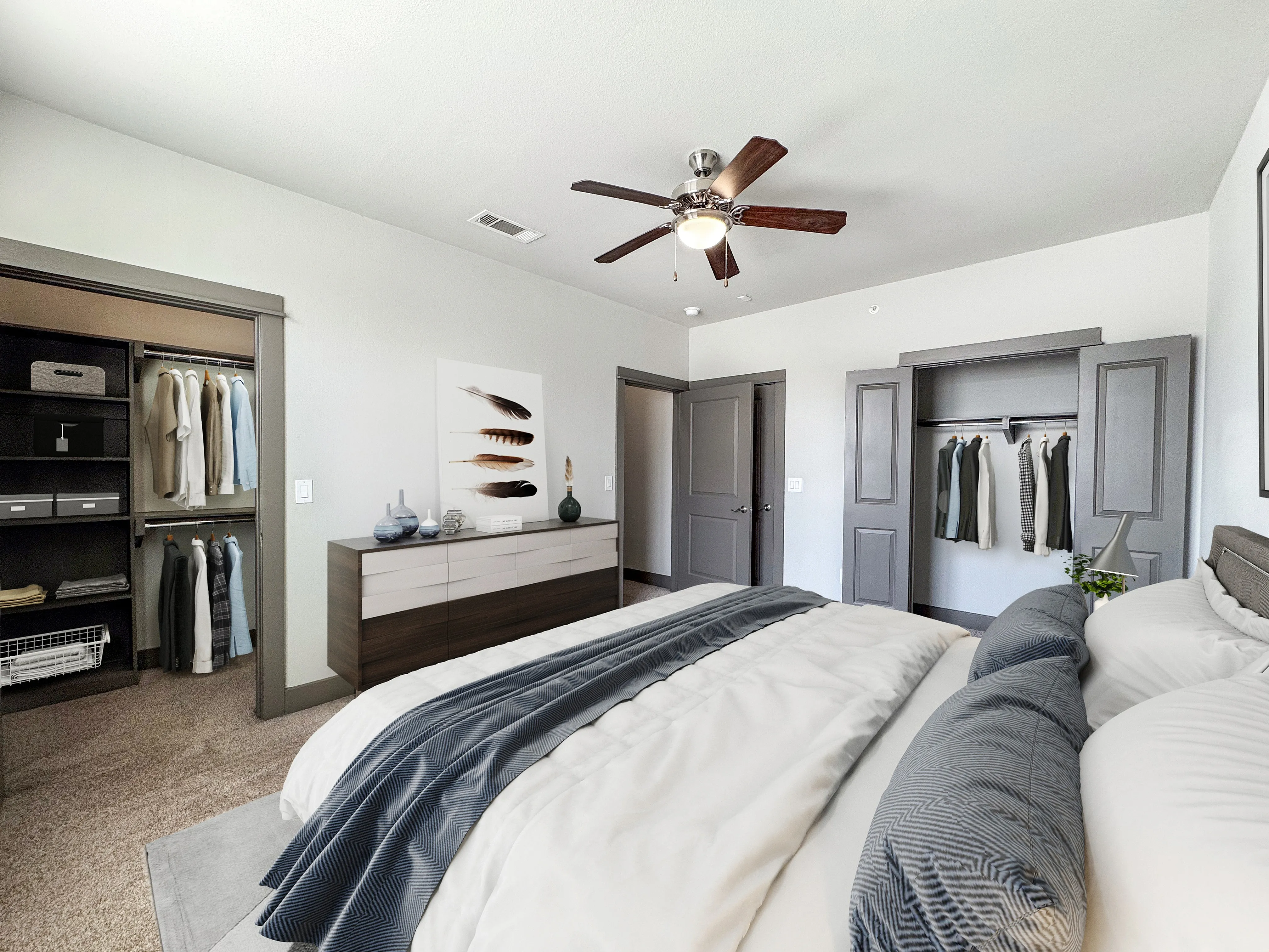 Elegant master bedroom with plush bedding, expansive closets, and stylish decor featuring modern furniture and neutral tones.