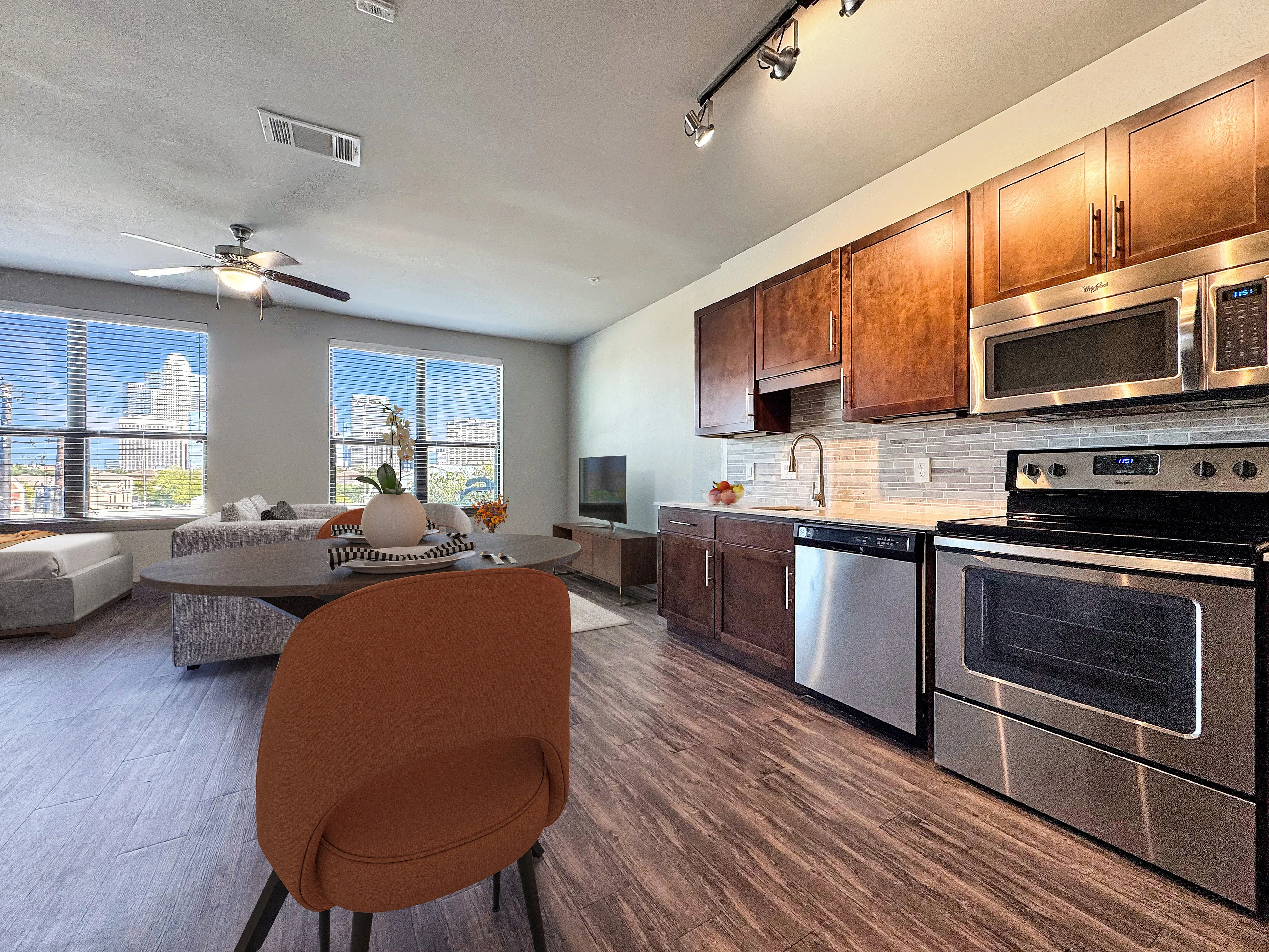 Modern open-concept apartment with sleek kitchen, hardwood floors, and a cozy living area with city views.