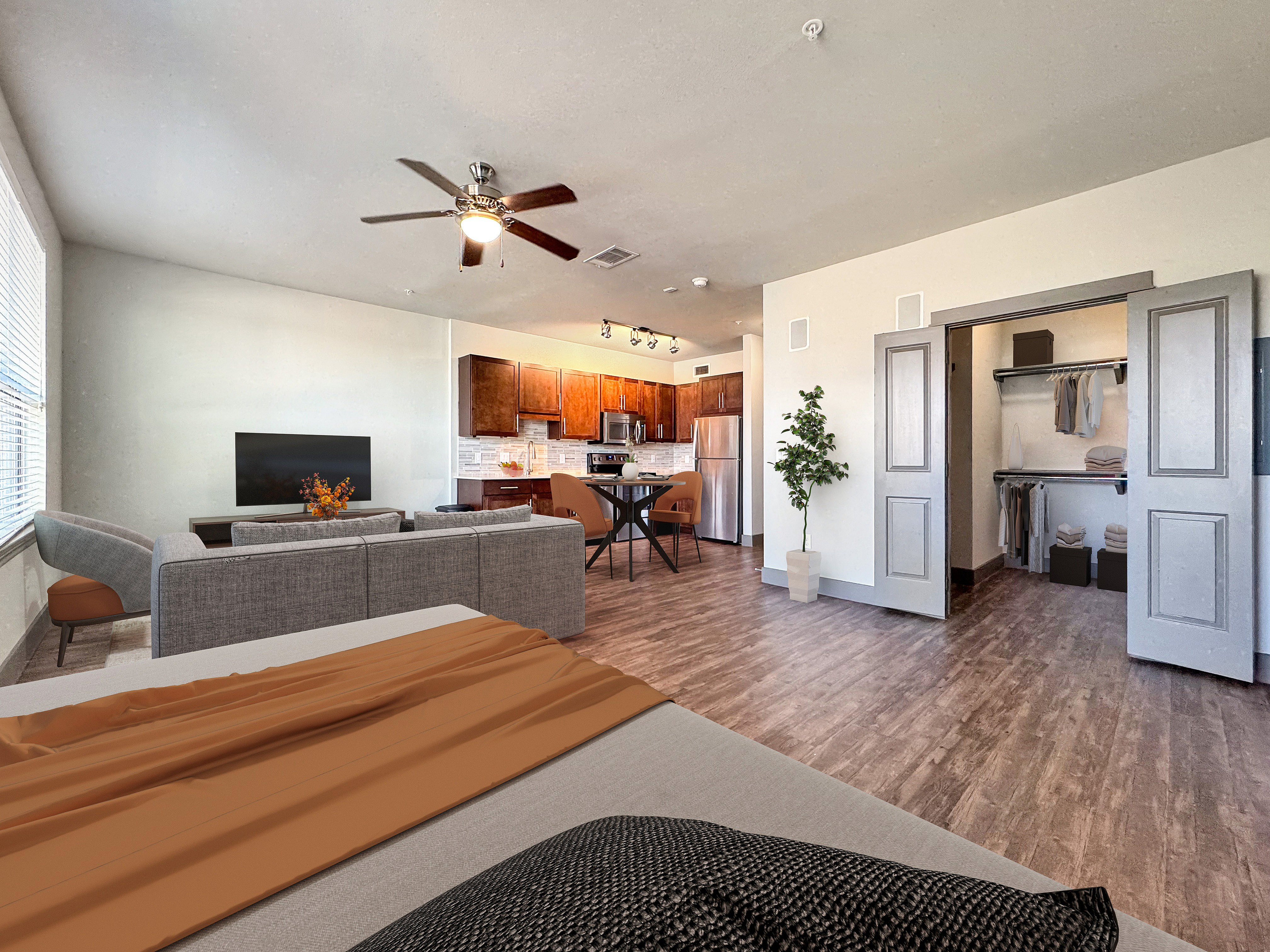 Modern open-concept apartment featuring a cozy living area, stylish kitchen with stainless steel appliances, and spacious closet space.