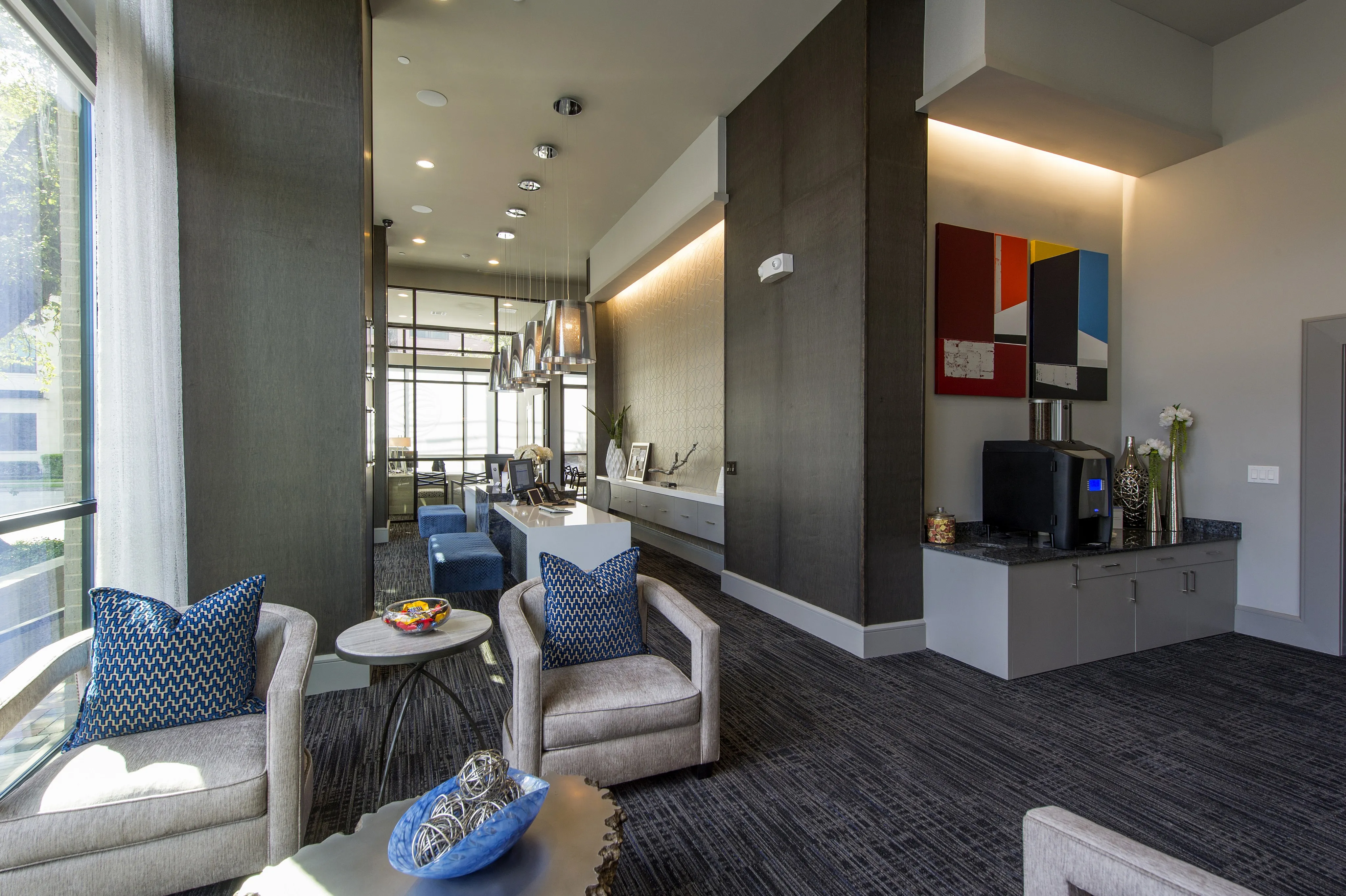Luxurious modern lounge area with plush seating, elegant decor, and ample natural light.