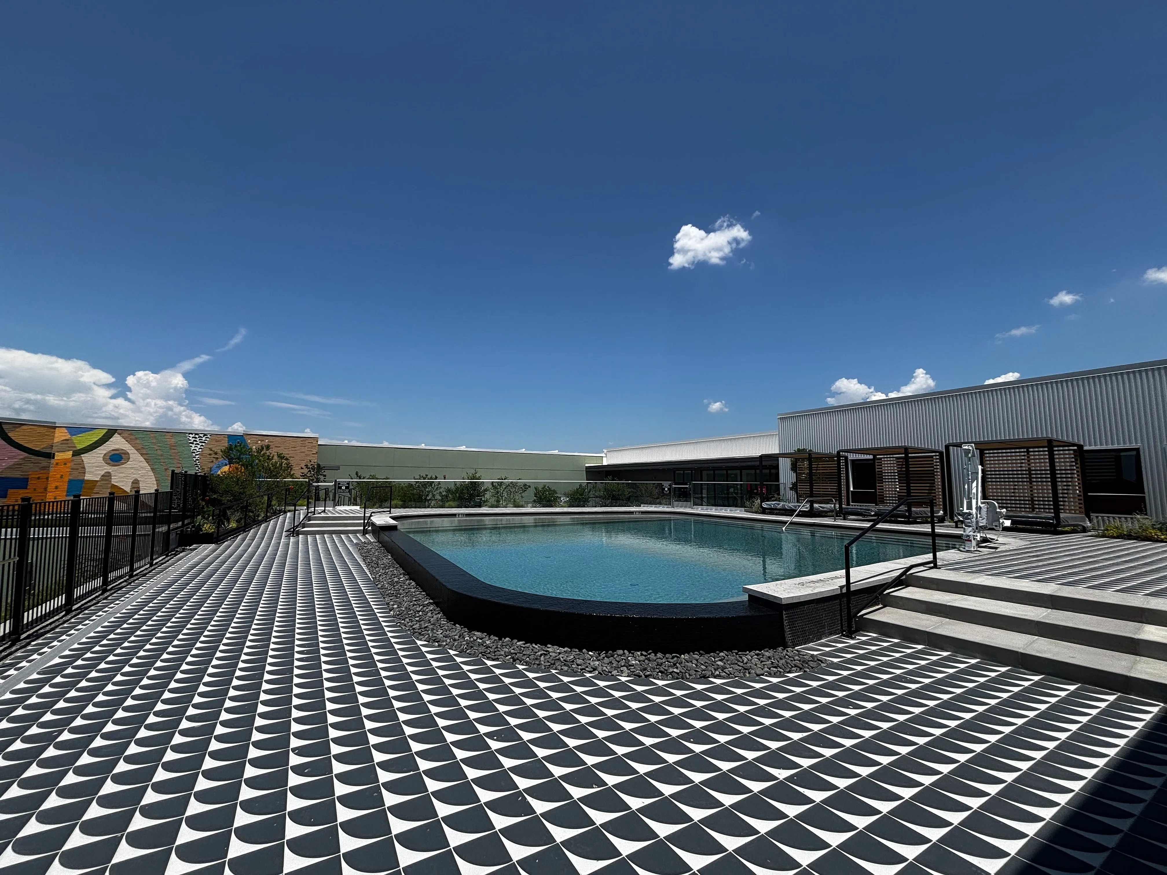 Luxurious rooftop swimming pool with stylish geometric tiling, perfect for relaxation and enjoying scenic views.