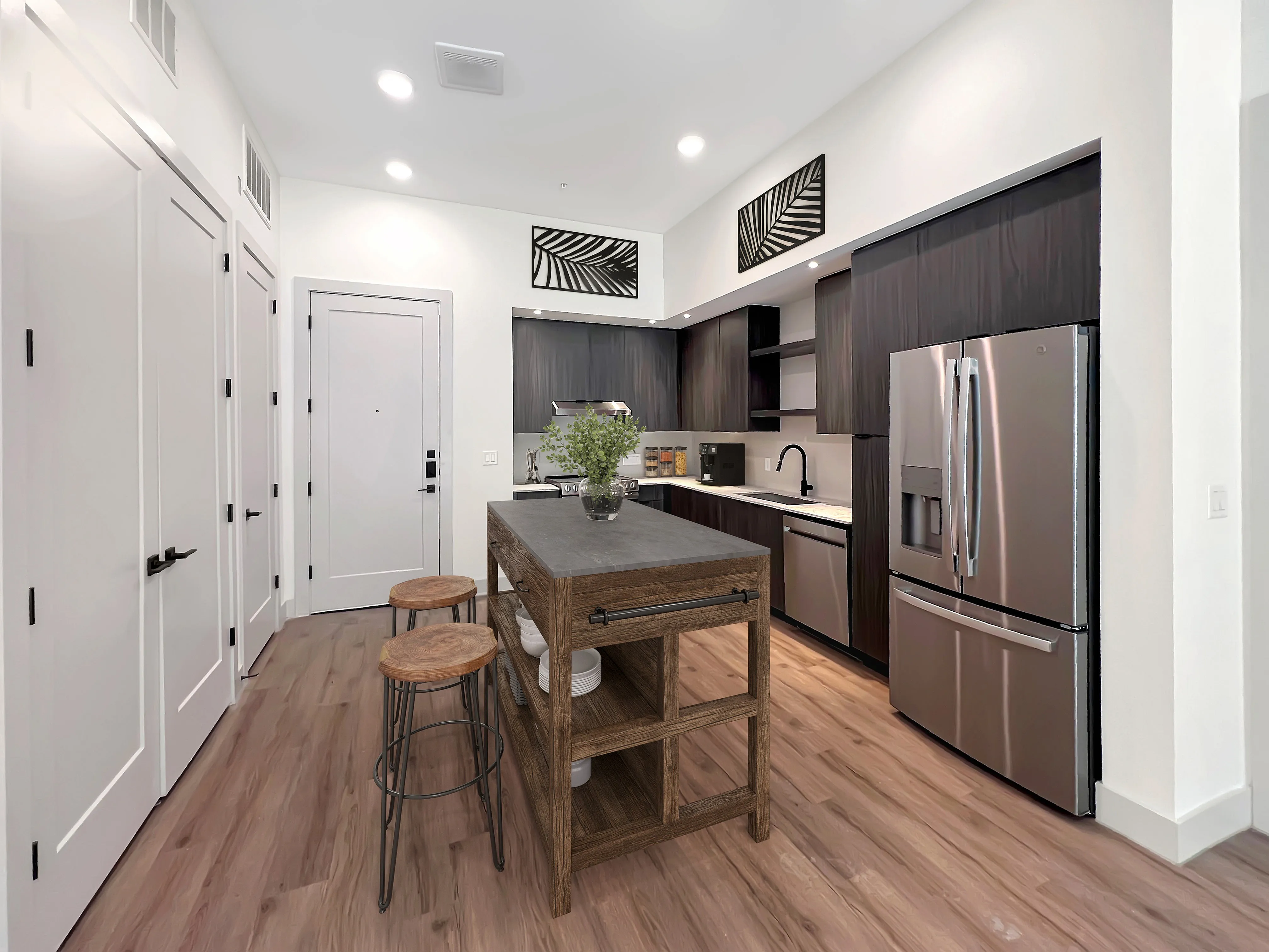 East Austin Apartments | Apartments in Austin | New apartments in Austin |Contemporary kitchen with sleek stainless steel appliances, elegant dark cabinetry, and a stylish wooden island in a bright, modern apartment.
