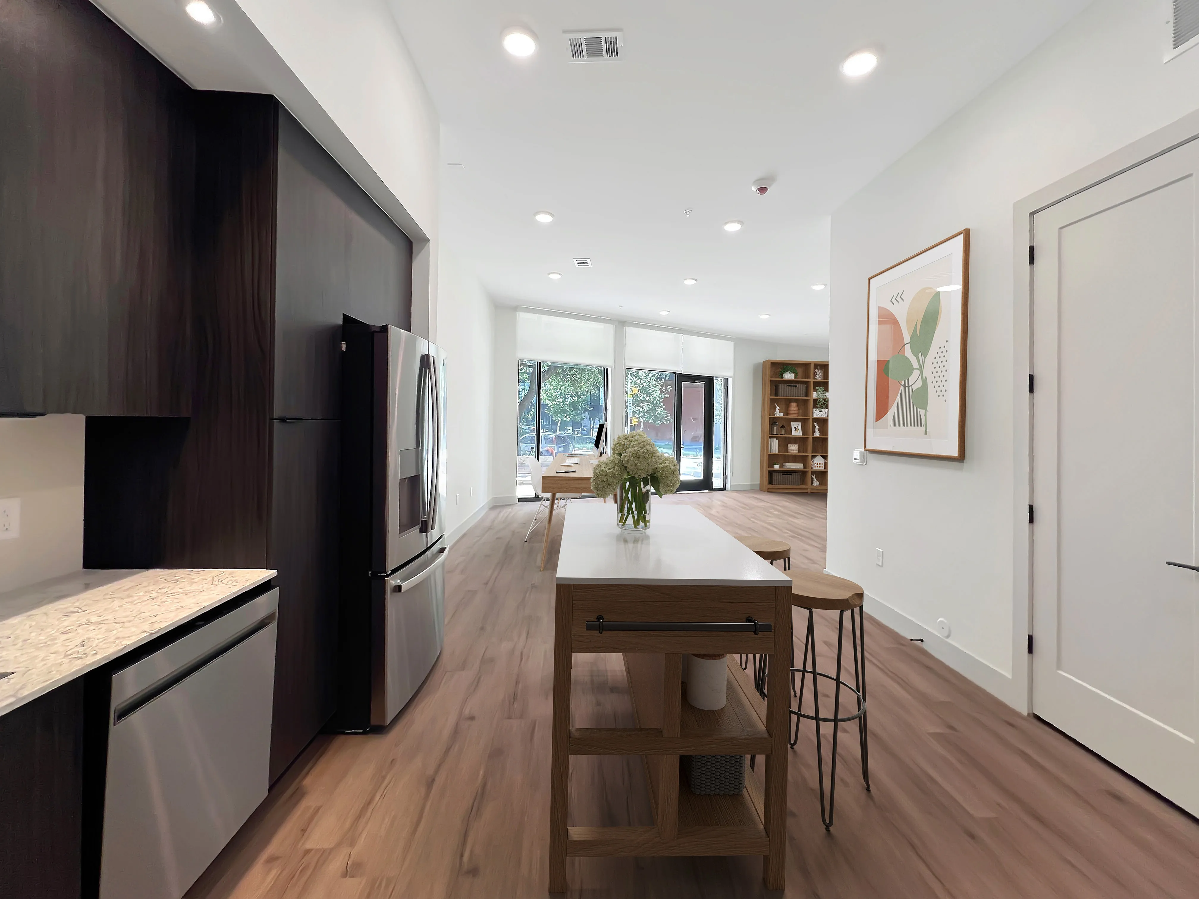 East Austin Apartments | Apartments in Austin | New apartments in Austin |Contemporary open-concept kitchen and living room with elegant hardwood flooring, stylish dark cabinetry, and modern appliances, bathed in natural light from expansive windows.