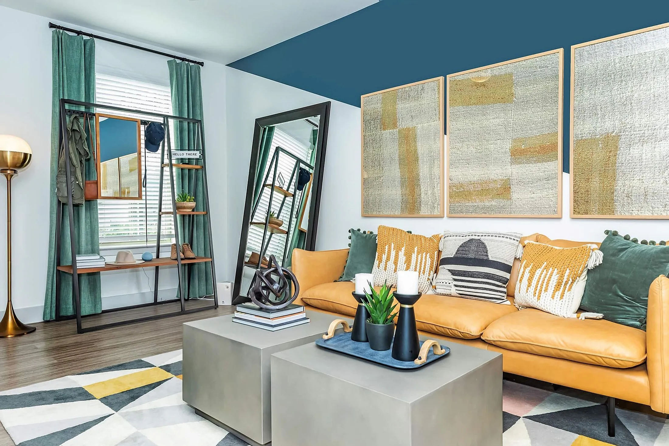 Chic living room with a cozy mustard sofa, modern artwork, and elegant decor accents. Features a stylish mirrored wardrobe and vibrant geometric rug, offering an inviting and sophisticated ambiance.