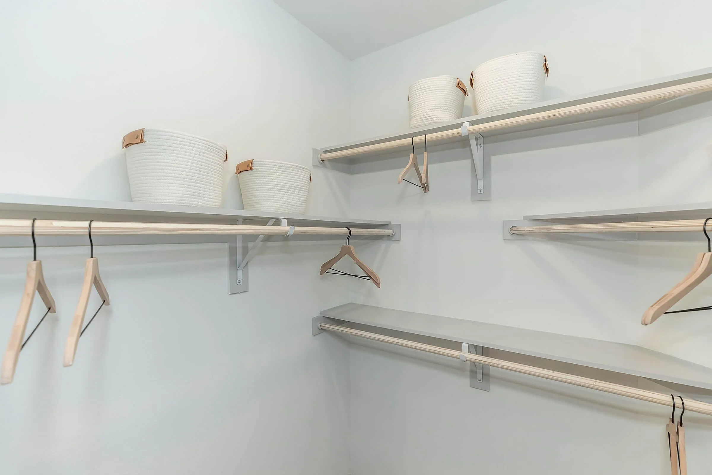 Spacious walk-in closet with sleek shelving and elegant baskets, perfect for stylish and organized living.