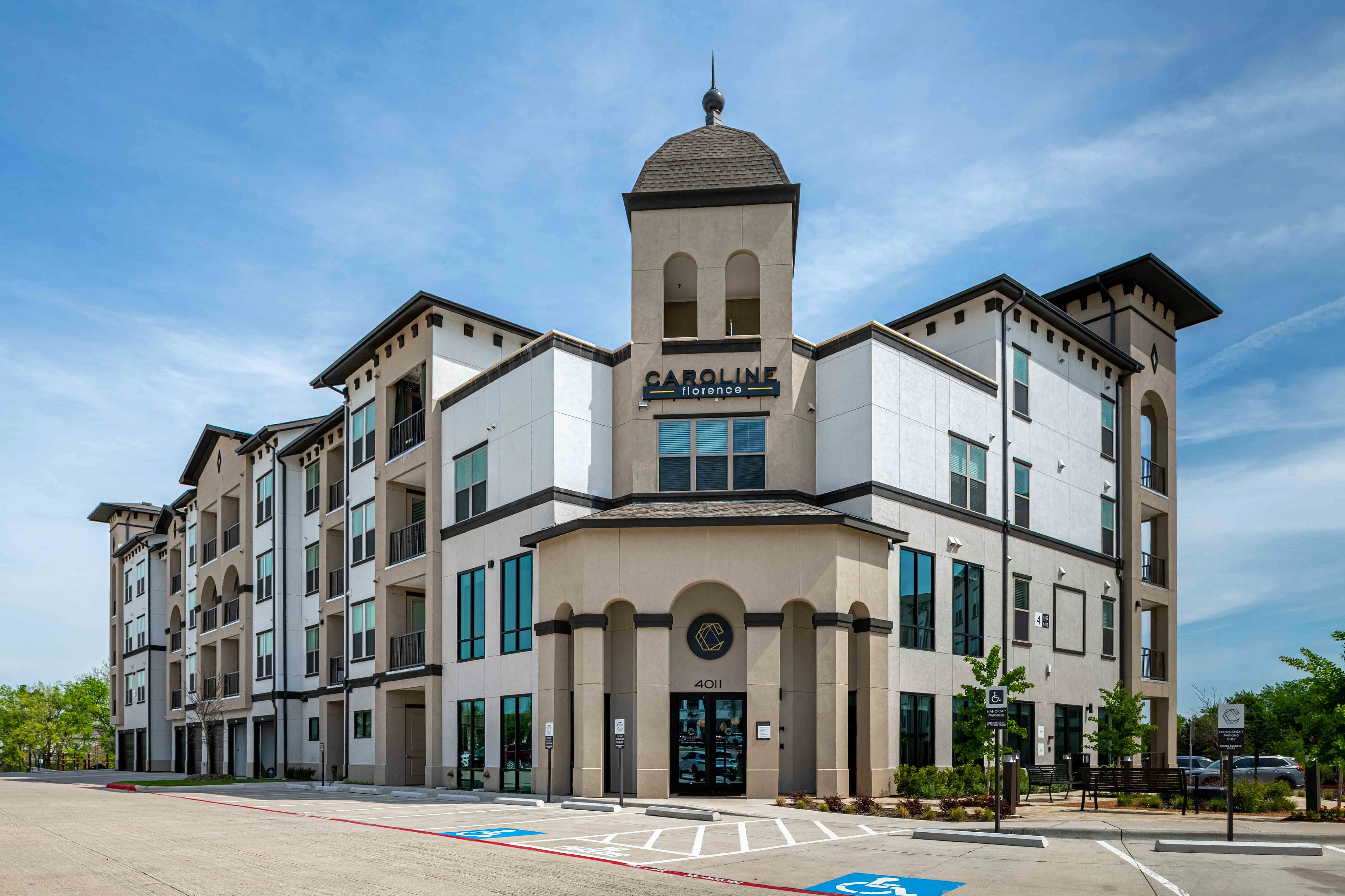 Elegant multi-story apartment building with modern architecture and inviting entrance, set against a clear blue sky.