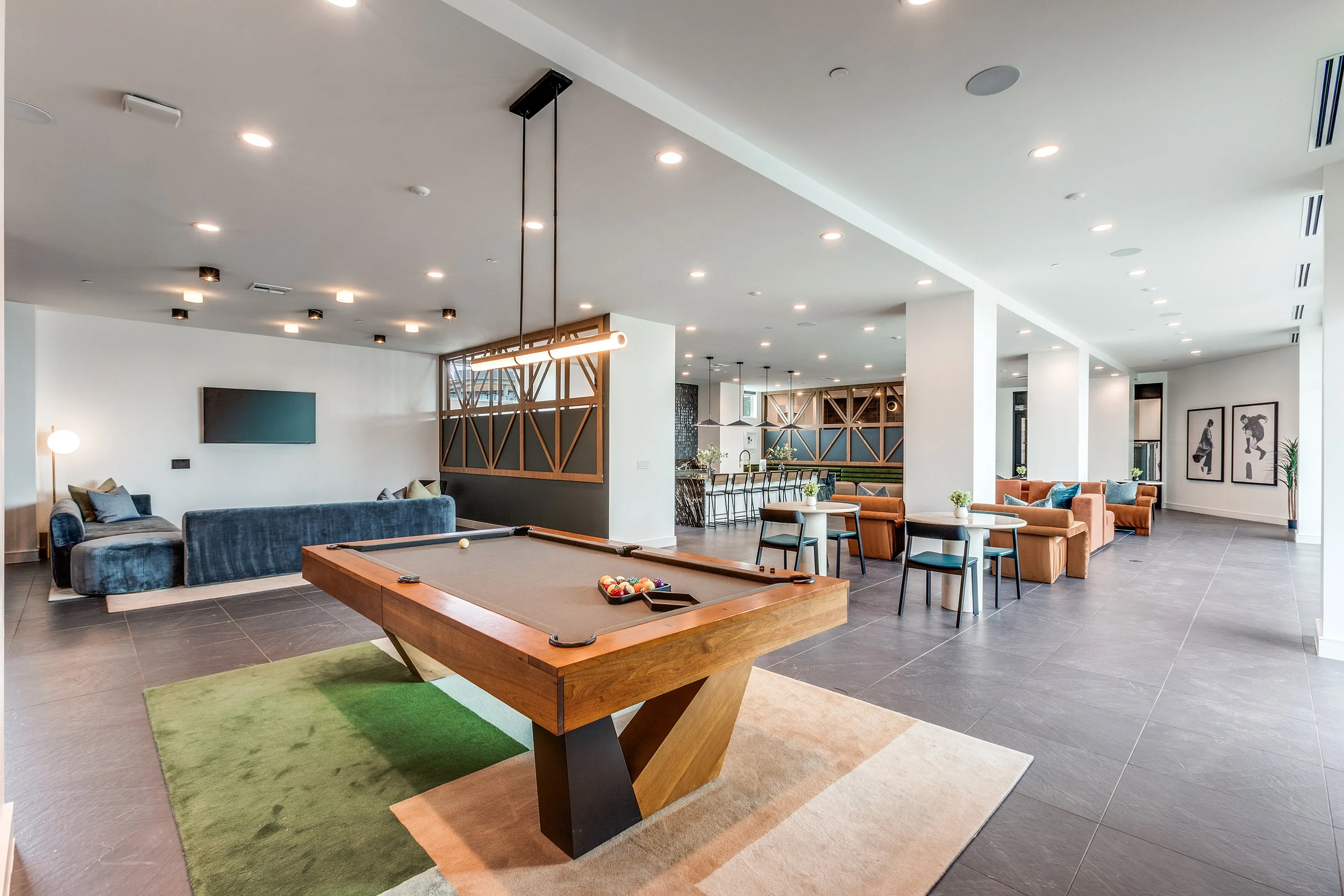 Luxurious apartment lounge featuring a sleek pool table, modern seating area, and ambient lighting.