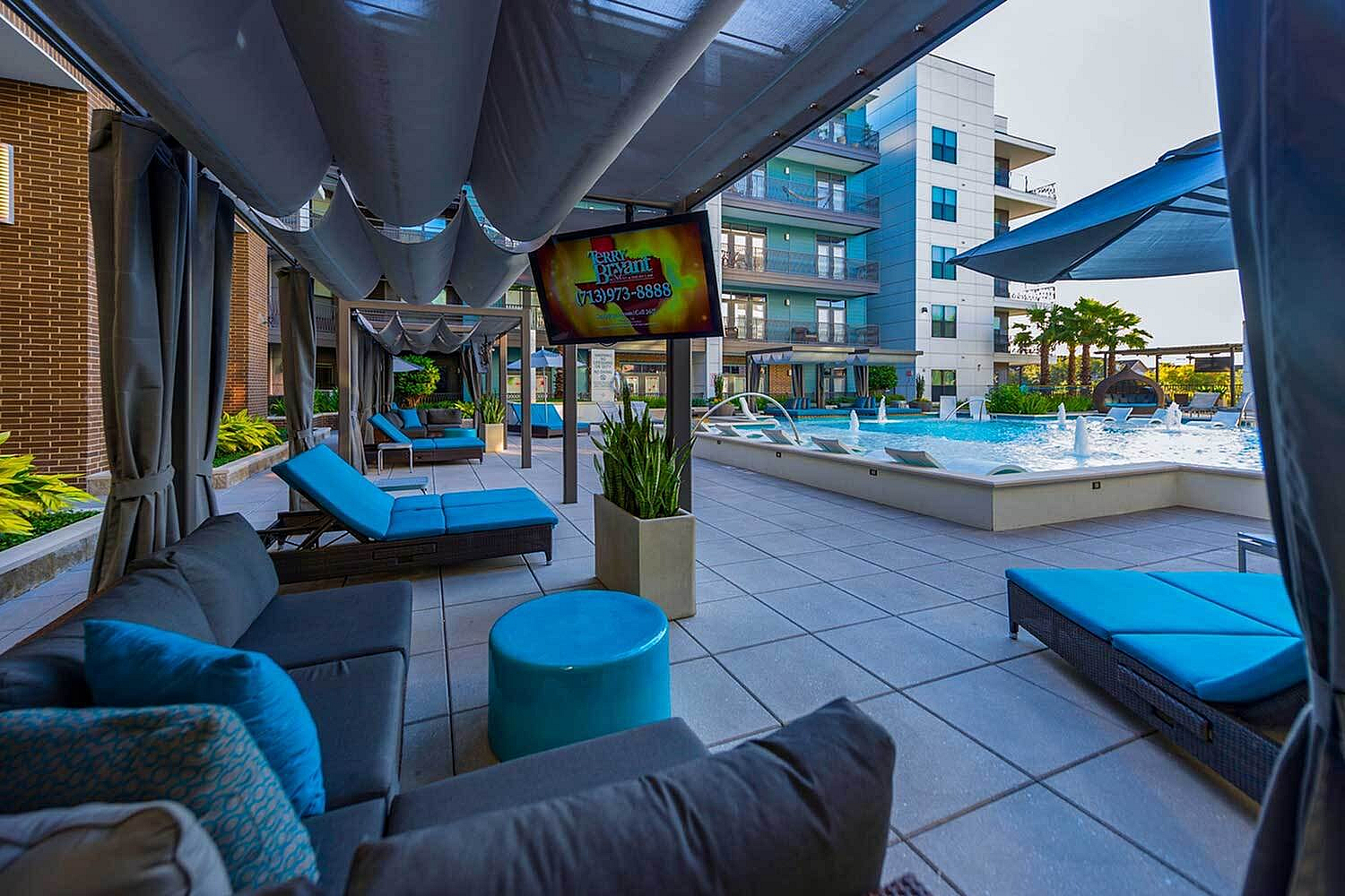 Luxurious apartment poolside oasis with stylish cabana seating, modern architecture, and vibrant greenery.