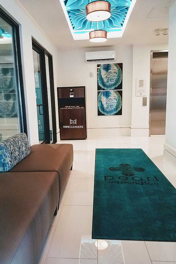Contemporary lobby with chic lighting, elegant wall art, and plush seating, featuring Pearl Washington branding for sophisticated ambiance.