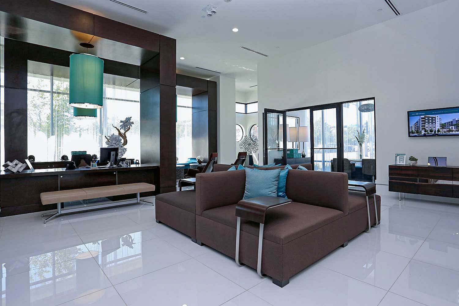 Modern apartment lobby showcasing elegant seating, stylish decor, and abundant natural light.