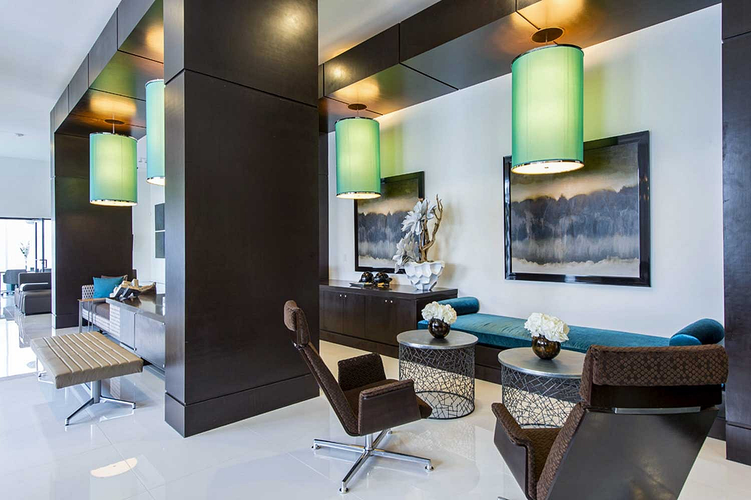 Chic and modern living area with elegant green pendant lighting, stylish seating, and contemporary art decor.
