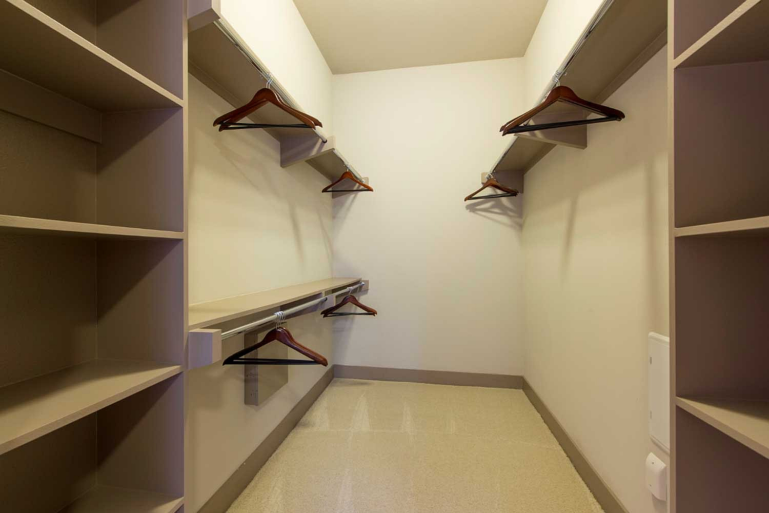 Spacious walk-in closet with ample shelving and hanging space, perfect for organizing your wardrobe with ease.